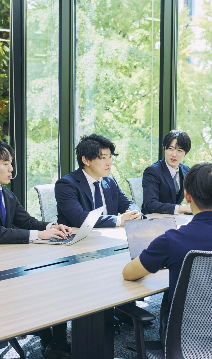 会議室で打ち合わせをする若手の社員